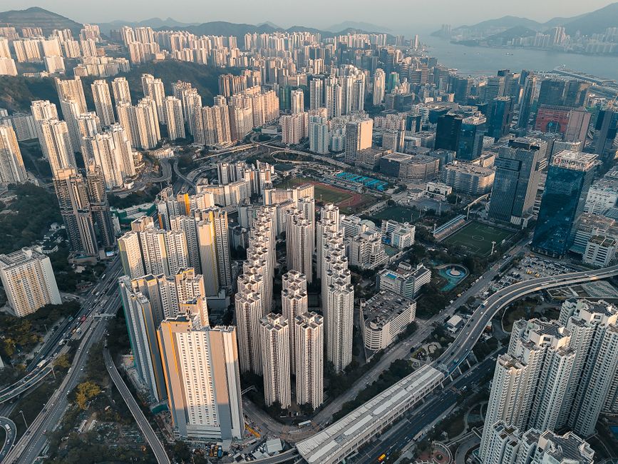 Explore the dense urban skyline of Kowloon, Hong Kong with towering skyscrapers and intricate roadways.