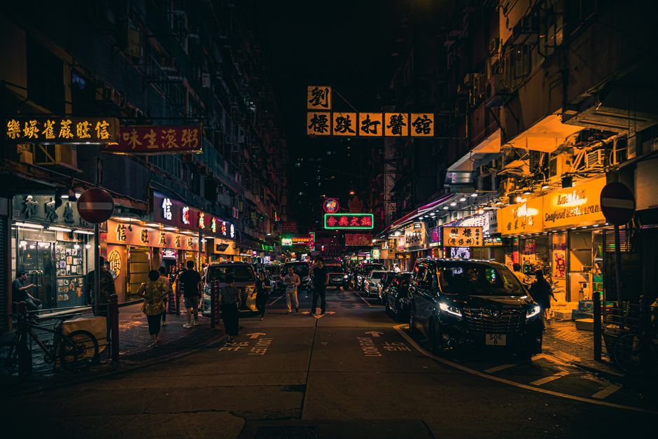 Explore the vibrant neon-lit streets of Hong Kong at night, bustling with energy and city life.